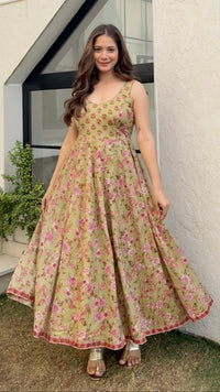 Woman in a floral dress standing in front of a modern house.